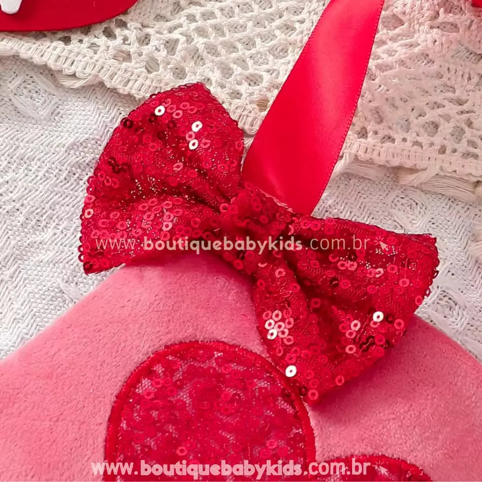 Laço vermelho de lantejoulas costurado ao body, combinando com um coração bordado no centro da peça. O brilho das lantejoulas adiciona um toque sofisticado e festivo.