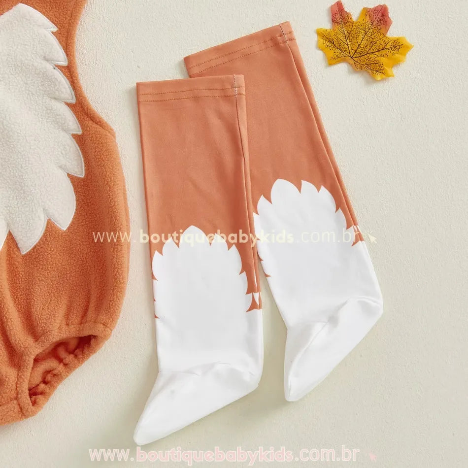 Body bebê laranja com detalhe peluciado branco no peitoral e meias temáticas que imitam patinhas de raposa.