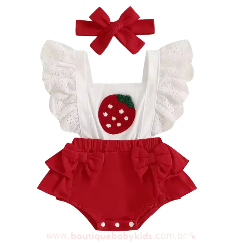 Romper vermelho para bebê com bordado de morango no peito, alças com babados rendados brancos e faixinha de cabelo combinando.