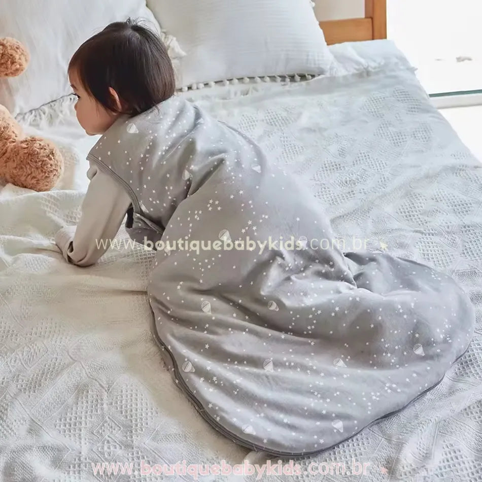 Bebê engatinhando sobre a cama vestindo o saco de dormir, mostrando sua flexibilidade para movimentos durante o sono.