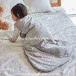 Bebê engatinhando sobre a cama vestindo o saco de dormir, mostrando sua flexibilidade para movimentos durante o sono.
