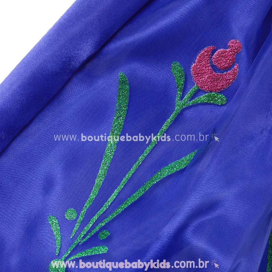 Estampa floral brilhante com glitter verde e rosa na saia azul do vestido fantasia Princesa Anna.