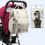 Bolsa Mochila Maternidade Elegance pendurada em um carrinho de bebê, destacando os ganchos para fixação.