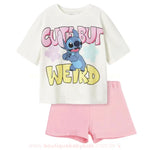 Conjunto infantil com camiseta branca estampada com o personagem Stitch e a frase "Cute But Weird" em letras coloridas, acompanhado de short rosa claro – roupa temática divertida para crianças, disponível na Boutique Baby Kids.